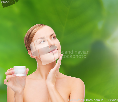 Image of woman applying cream on her skin