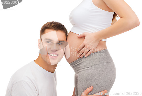 Image of happy father listening belly of his pregnant wife