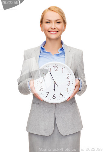 Image of smiling businesswoman with wall clock