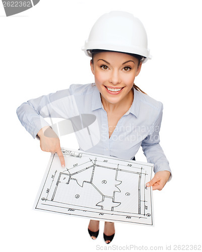 Image of businesswoman in helmet showing with blueprint