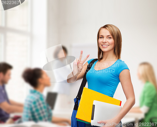 Image of female student with bag, tablet pc and folders