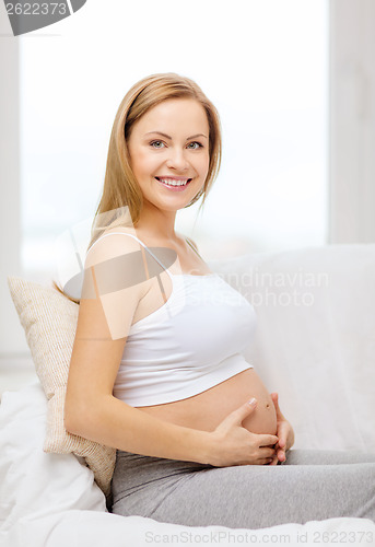 Image of happy pregnant woman touching her belly