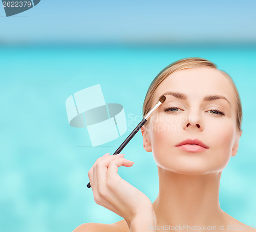 Image of beautiful woman with makeup brush