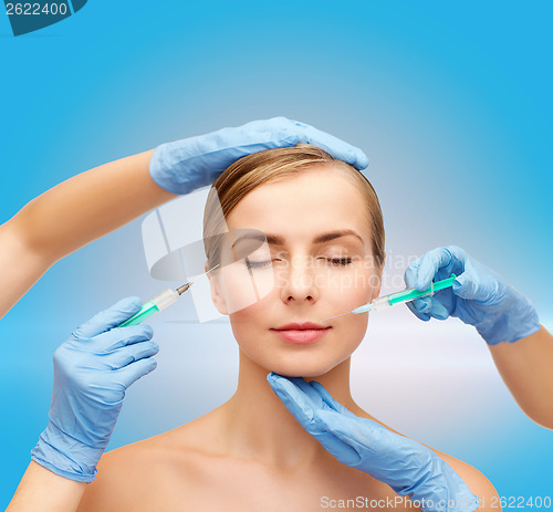 Image of woman face and beautician hands with syringe