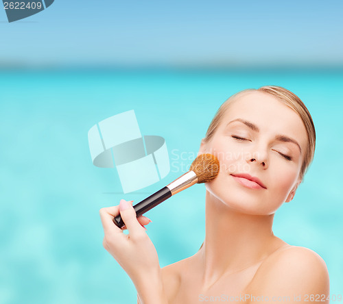 Image of beautiful woman with makeup brush