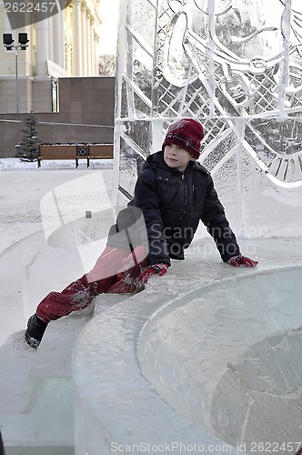 Image of Portrait of the boy sitting on the edge of an ice slope.