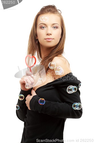 Image of lovely girl with heart-shaped blower