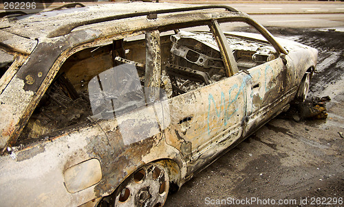 Image of burnt-out car in city