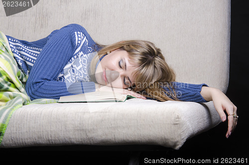 Image of The girl fell asleep on sofa with a book