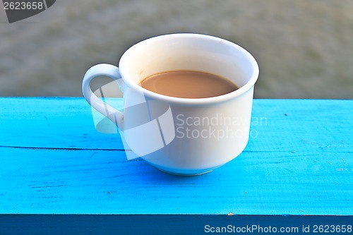 Image of hot coffee in white cup on wooden