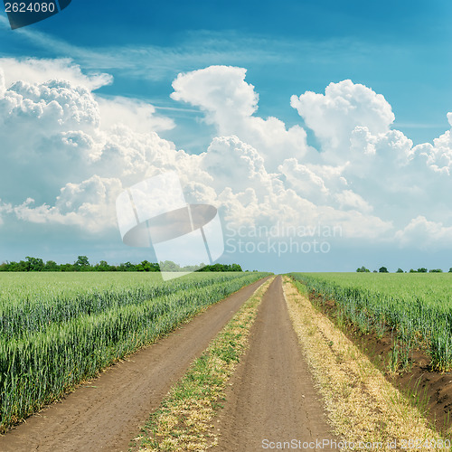 Image of cloudy sky over road in green field
