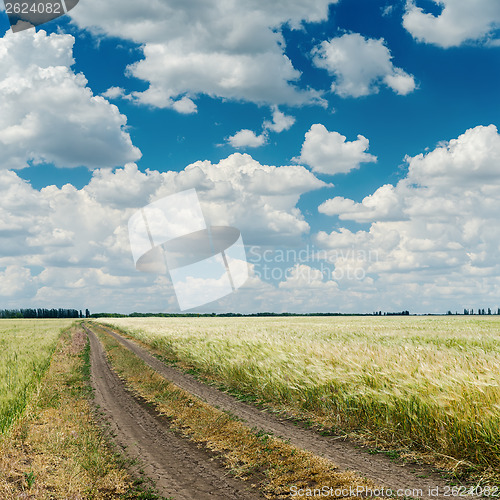 Image of dramatic clouds over road in agriculture field