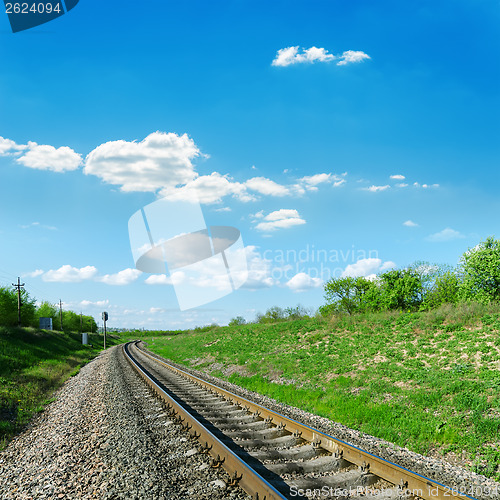 Image of railroad in green landscape and blue sky