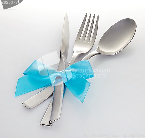 Image of knife fork and spoon with blue ribbon