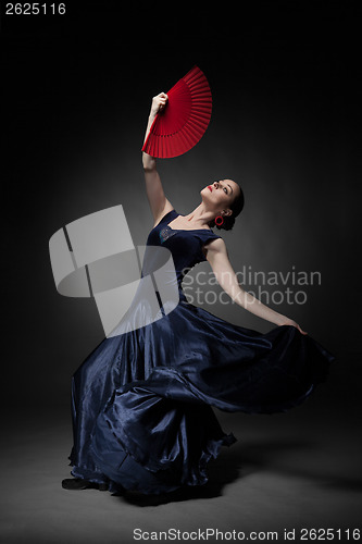 Image of young woman dancing flamenco on black