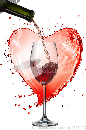 Image of Red wine pouring into glass with splash against heart isolated o