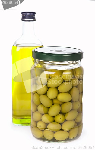 Image of Green olives preserved in bank and a bottle of olive oil