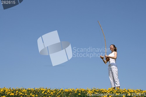 Image of Girl playing berimbau in spring meadow