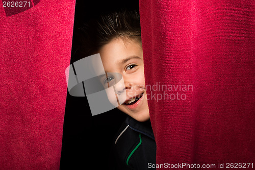 Image of Child appearing beneath the curtain