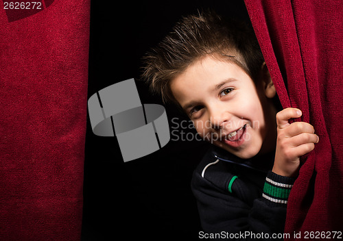 Image of Child appearing beneath the curtain