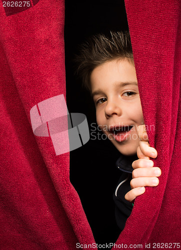 Image of Child appearing beneath the curtain