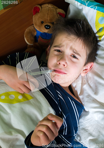Image of Sick child in bed with teddy bear