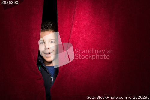 Image of Child appearing beneath the curtain