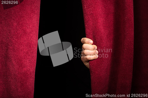 Image of Hand appearing beneath the curtain.