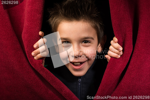 Image of Child appearing beneath the curtain