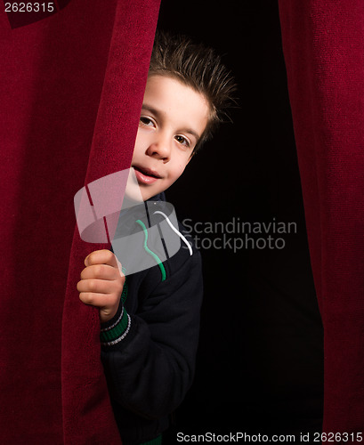 Image of Child appearing beneath the curtain