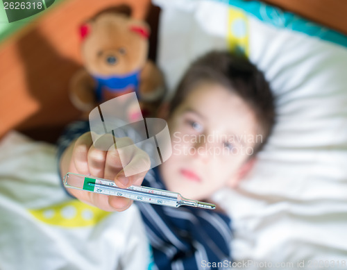 Image of Sick child in bed with teddy bear