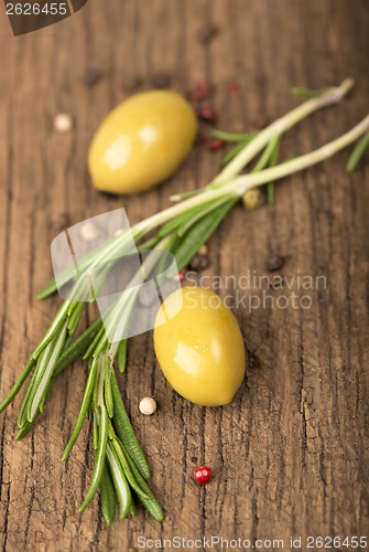 Image of olives and rosemary on a wooden background