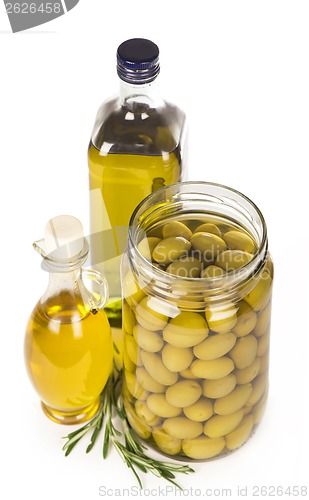 Image of Green olives preserved in bank, bottle of olive oil, rosemary