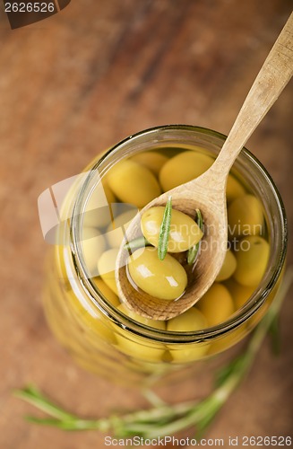 Image of Close up green olives in bank,  rosemary