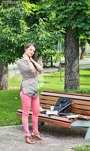 Image of Young Woman Massaging her Nape in a Park