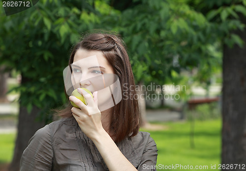 Image of Portrait of a Woman Eating a Green Apple