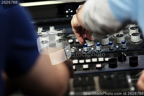 Image of Hands on a sound mixer