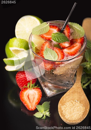 Image of alcoholic punch cocktail with ice and strawberry