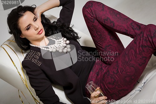 Image of Seductive brunette holding a glass of champagne