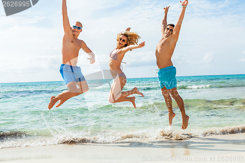 Image of young happy friends havin fun on the beach