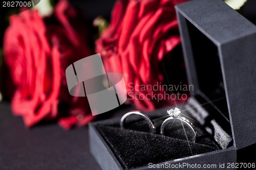 Image of Engagement ring with a bunch of red roses