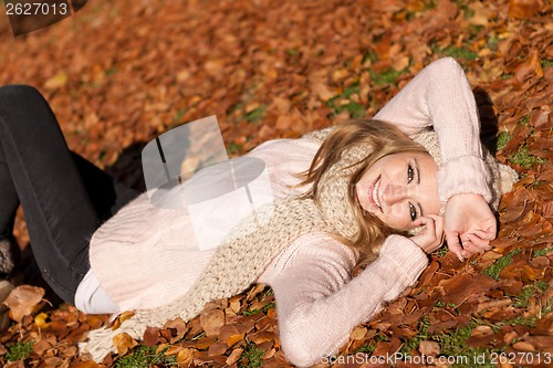 Image of young smiling woman with hat and scarf outdoor in autumn