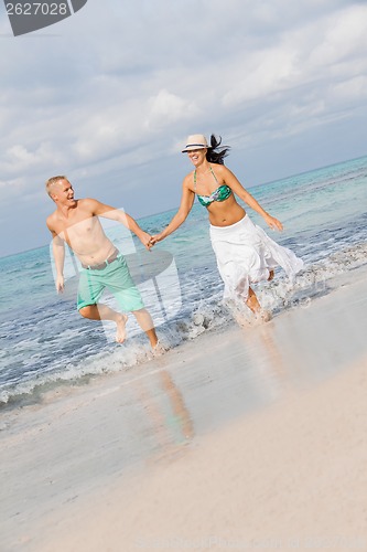 Image of young happy couple walking on beach sunset holiday