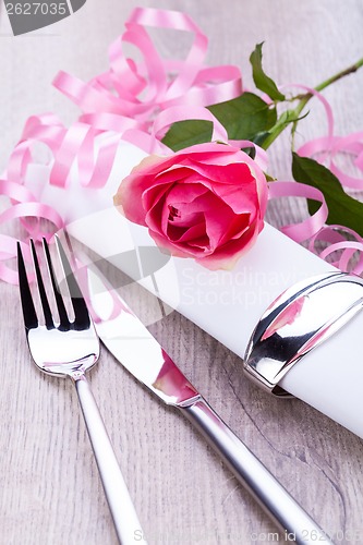 Image of Table setting with a single pink rose