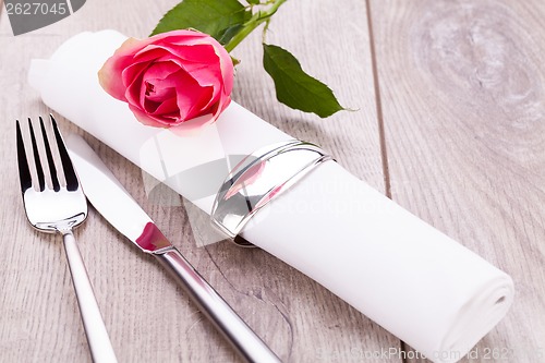 Image of Table setting with a single pink rose