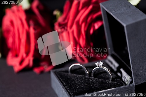 Image of Engagement ring with a bunch of red roses