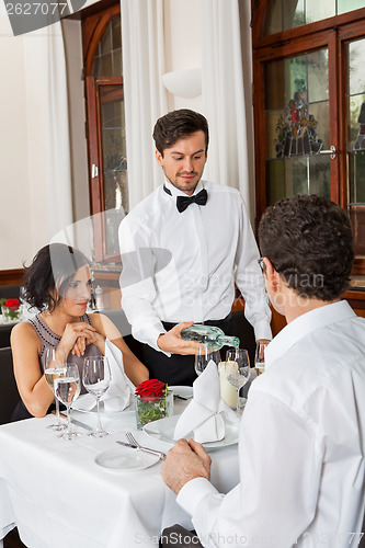 Image of young smiling couple at the restaurant 