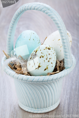 Image of Three natural blue Easter eggs in a basket