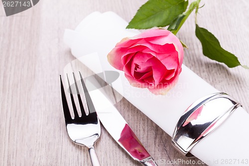 Image of Table setting with a single pink rose