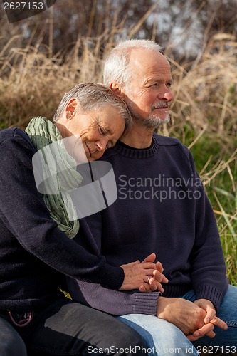 Image of happy senior couple relaxing together in the sunshine